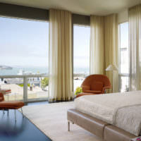 Панорамные окна гостиной с кремовыми шторами