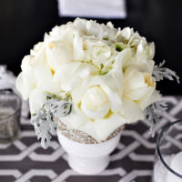 Праздничный букет из белых цветов на столе молодоженов