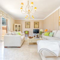 Белая мебель и яркие полоски на обоях в гостиной