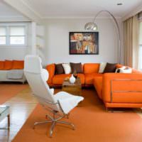 Интерьер гостиной с оранжевым диваном около окна