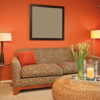 Серый квадрат на фоне оранжевых стен в гостиной