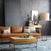 Коричневый диван в интерьере комнаты с серыми стенами