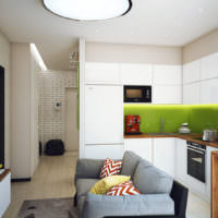 Интерьер небольшой кухни-гостиной с серым диваном