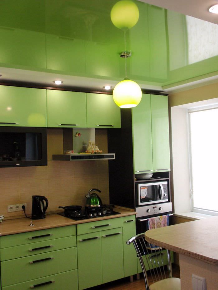 Зеркальный натяжной потолок на кухне с зеленым гарнитуром