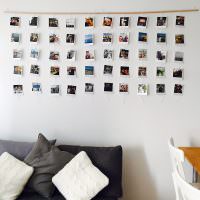 Белая стена с фотографиями на деревянной планке