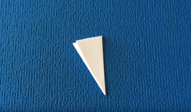 Треугольник из бумаги на синем фоне