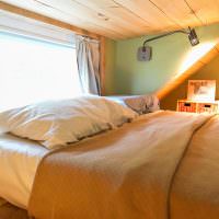 Спальня с низким потолком на чердаке дачного дома
