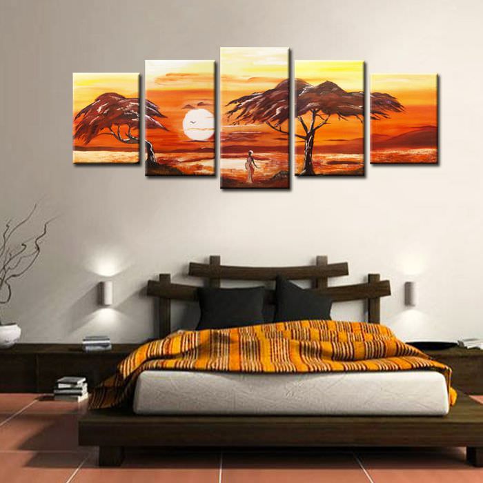 Низкая кровать в спальне с картинами на стене