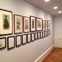 Коллекция картин на стене узкого коридора