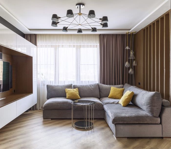 Серый диван угловой формы в интерьере гостиной