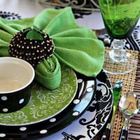 Зеленые салфетки на тарелках с черным орнаментом