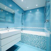 Белая подвесная тумба в ванной с голубой плиткой